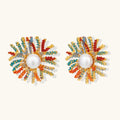Vibrant starburst stud earrings with multicolor enamel rays and white pearl centers on gold-plated setting