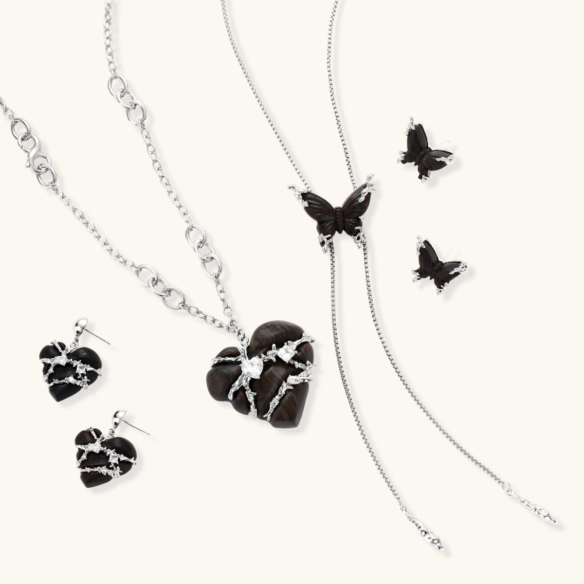 Dark wood butterfly earrings and necklace with silver chain accents on white background, showing natural grain texture.